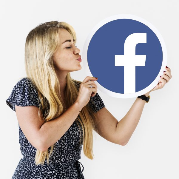 Woman blowing a kiss to a Facebook icon